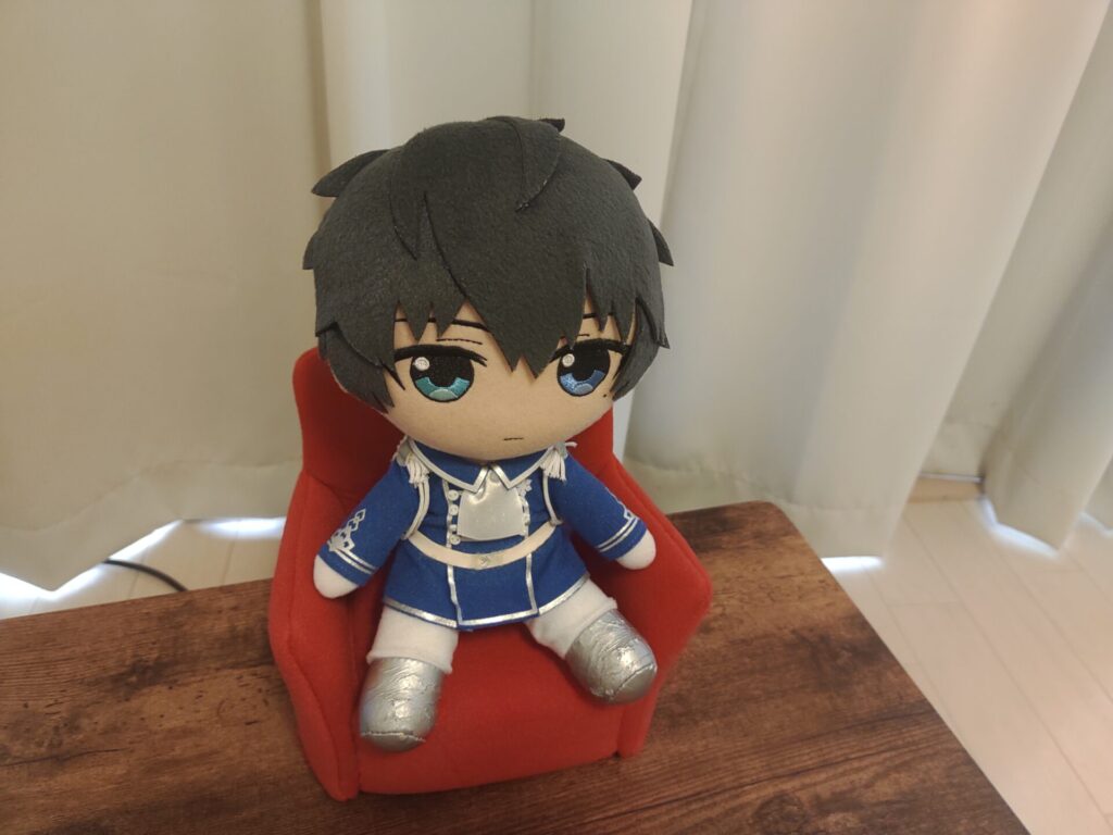 赤いソファに座る恭二ぬい